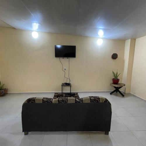 a living room with a couch and a flat screen tv at Departamento Luna in Palenque