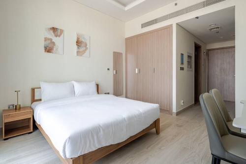 a bedroom with a large white bed and a desk at Cozy studio Pet Friendly Pool, Gym, Water Near Downtown in Dubai