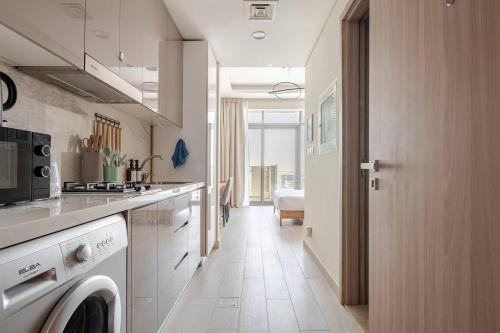 a kitchen with a washer and dryer in a room at Cozy studio Pet Friendly Pool, Gym, Water Near Downtown in Dubai