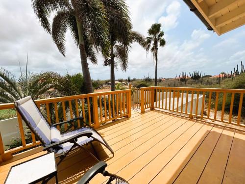 a wooden deck with a chair and palm trees at Paradera Palms 2 Bedroom in Paradera