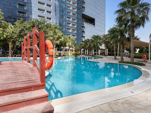 a large swimming pool with a slide in a building at Desert Key - Platinum Apartments in Gate Tower, Al Reem Island in Abu Dhabi