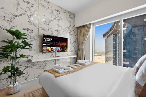 a white bedroom with a large bed and a tv at Desert Key - Platinum Apartments in Gate Tower, Al Reem Island in Abu Dhabi