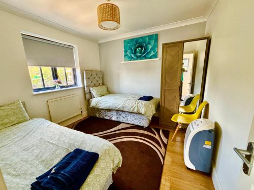 a small bedroom with two beds and a mirror at Conveniently located 3 bed spacious home for couples, families and groups in Ipswich in Ipswich