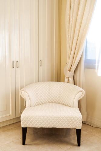 a white chair sitting in front of a window at Argaka Luxury Residence in Paphos City