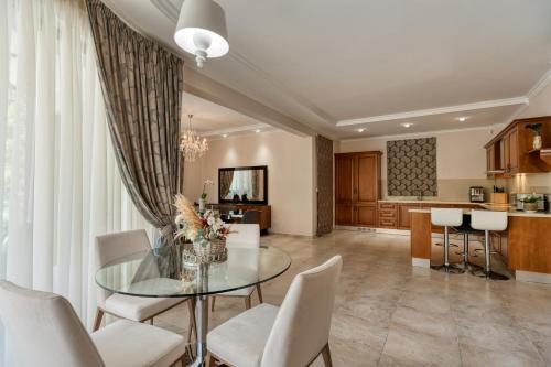 a dining room and kitchen with a glass table and chairs at Argaka Luxury Residence in Paphos City
