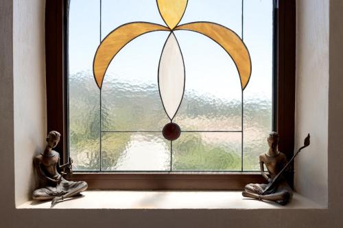 two statues sitting on a window sill looking out at a window at Argaka Luxury Residence in Paphos City