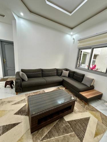 a living room with a couch and a table at Pearl Haven Suite - Appartement F2 bord de mer in Dakar