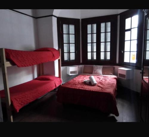 a bedroom with a red bed and two loft beds at La Casona-Departamentos in Mar del Plata