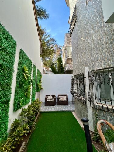 a courtyard with a green lawn next to a building at Pearl Haven Suite - Appartement F2 bord de mer in Dakar