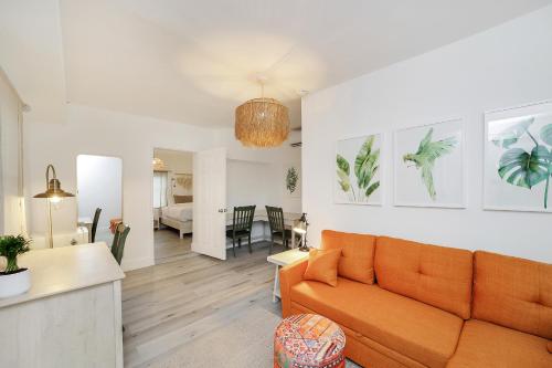 a living room with an orange couch and a dining room at Alton Rd By At Mine Hospitality in Miami Beach