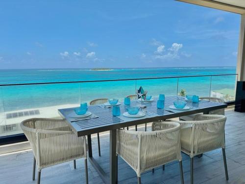 a table with chairs and a view of the ocean at Almare Apartamentos nuevos in Gustavo Rojas Pinilla International