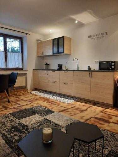 a kitchen with wooden cabinets and a table in a room at Guesthouse Les Tilleuls in Fleurus