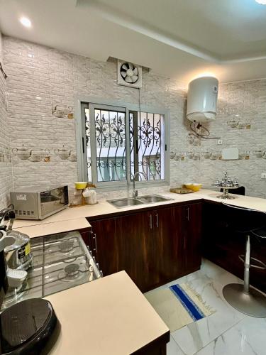 a kitchen with a sink and a window at Pearl Haven Suite - Appartement F2 bord de mer in Dakar