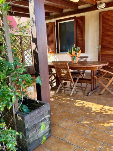 a patio with a wooden table and chairs at Villa Stintino in Stintino