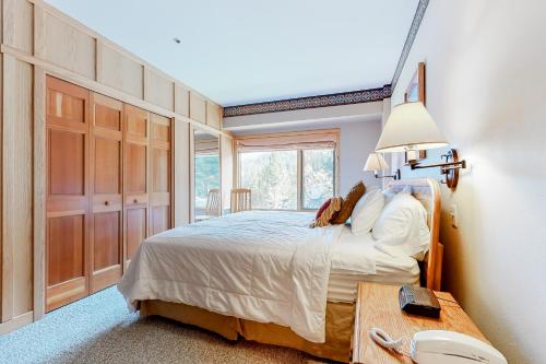 a bedroom with a bed and a table with a lamp at Shoshone 1904 in Big Sky