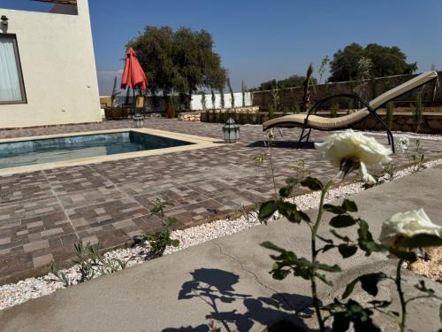 une piscine avec un banc et une fleur dans l'établissement Sweety Mogador, à Essaouira