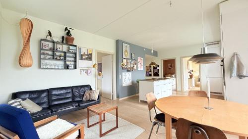 a living room with a black leather couch and a table at ApartmentInCopenhagen Apartment 1634 in Copenhagen