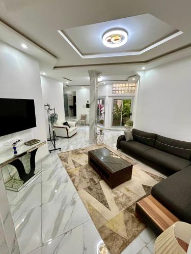 a living room with a couch and a tv at Pearl Haven Suite - Appartement F2 bord de mer in Dakar