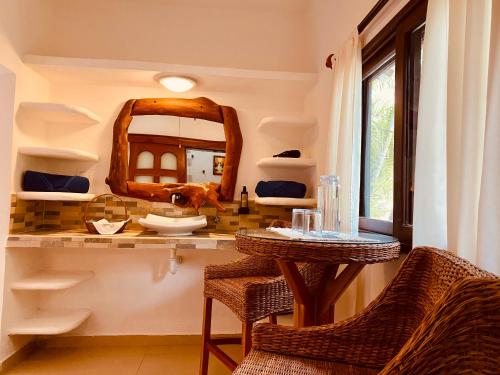 a bathroom with a vanity with a mirror and wicker chairs at Hotel Para Ti - Adults Only in Holbox Island