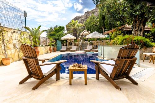 two chairs and a table next to a pool at The Aegean Gate Hotel in Bodrum City