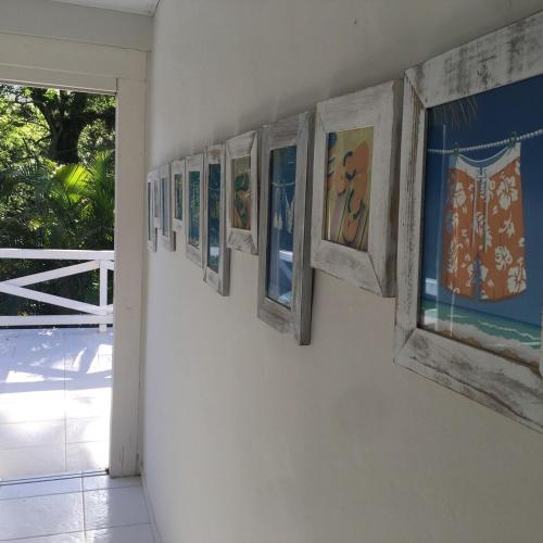 a group of paintings hanging on a wall at Casa de la playa in São Paulo