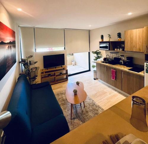 Una sala de estar con un sofá azul y una mesa. en Luxurious studio, Playa del Carmen, en Playa del Carmen