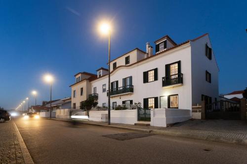 a large white building with lights on a street at Casa do Sol da Granja in São Félix da Marinha