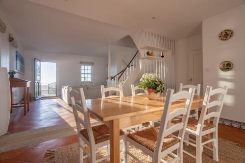 a dining room with a wooden table and chairs at Casa do Sol da Granja in São Félix da Marinha