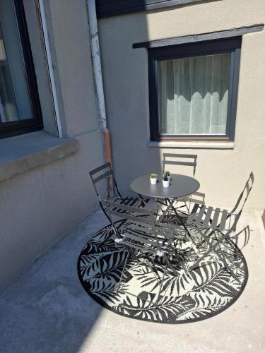 une table et deux chaises assises sur une terrasse dans l'établissement Au Bord de L'Eau, à Trith-Saint-Léger