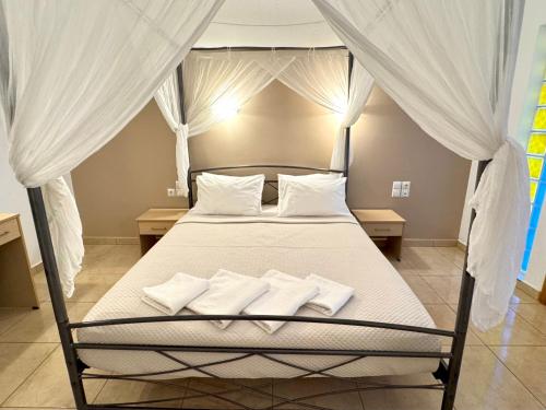 a bedroom with a bed with white sheets and pillows at Pachia Ammos Falasarna in Falasarna