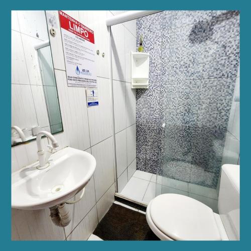 a bathroom with a shower and a toilet and a sink at Acquarela Hostel in Arraial do Cabo