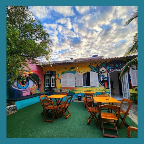 a restaurant with tables and chairs in front of a building at Acquarela Hostel in Arraial do Cabo