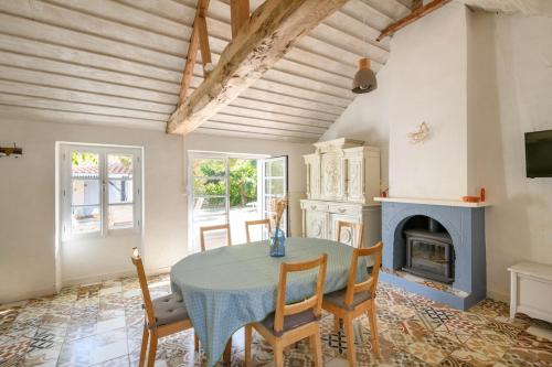 a dining room with a table and a fireplace at Charmante maison vendéenne proche de la plage in Notre-Dame-de-Monts