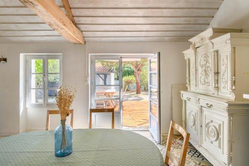une salle à manger avec une table avec un vase dessus dans l'établissement Charmante maison vendéenne proche de la plage, à Notre-Dame-de-Monts