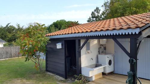 a house with a washing machine in a yard at Charmante maison vendéenne proche de la plage in Notre-Dame-de-Monts