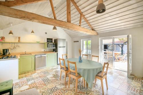 une cuisine et une salle à manger avec une table et des chaises dans l'établissement Charmante maison vendéenne proche de la plage, à Notre-Dame-de-Monts