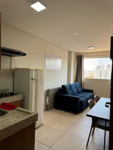 a living room with a blue couch and a kitchen at CONDOMÍNIO EVEREST-Flat em Caldas Novas-GO in Caldas Novas