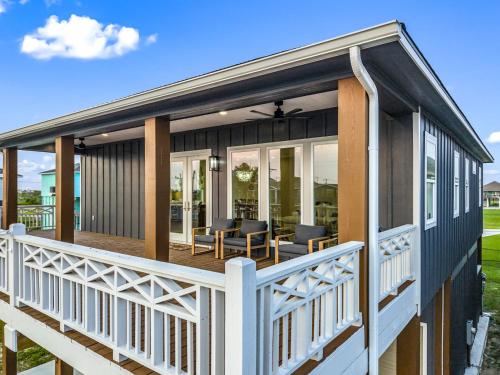 a house with a wrap around deck with chairs and tables at Beach Access Games Firepit Brand New in Bolivar Peninsula