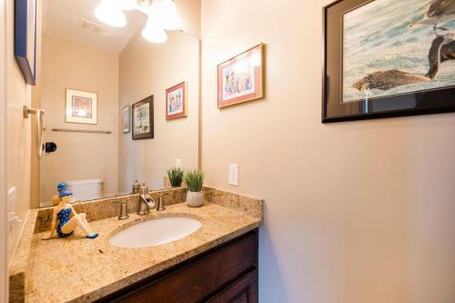 a bathroom with a sink and a mirror at Paws. . . and RELAX. A PF getaway in the clouds in Carolina Beach
