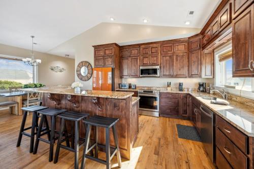 a kitchen with wooden cabinets and a island with bar stools at Paws. . . and RELAX. A PF getaway in the clouds in Carolina Beach