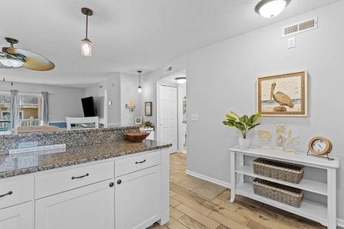 a kitchen with white cabinets and a counter top at Cast a Waves. Condo with partial Atlantic views and a POOL in Carolina Beach
