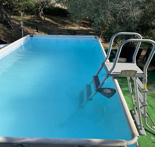 una piscina con una silla y una piscina azul en Casa in campagna Il Colibrì, en Sacrofano