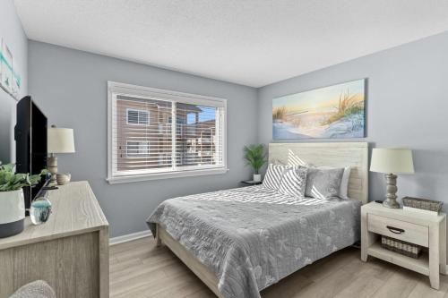 a bedroom with a bed and a window at Cast a Waves. Condo with partial Atlantic views and a POOL in Carolina Beach