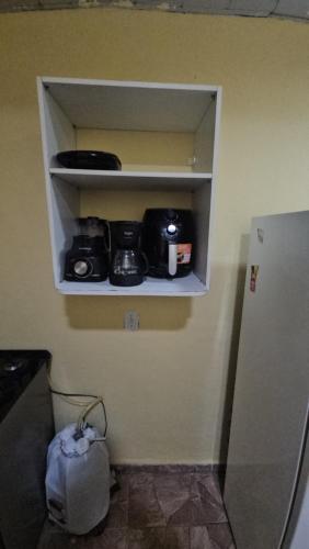 a cupboard with cameras on it next to a refrigerator at Cantinho bom! in Manaus