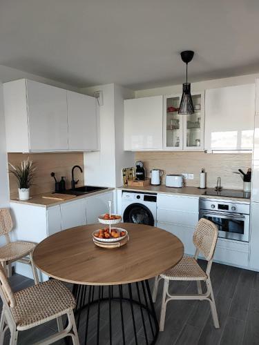 une cuisine avec une table avec un bol de fruits dessus dans l'établissement Appartement classé 3 étoiles à 150m de la plage, à Fréjus