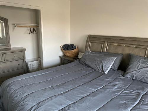 a bedroom with a bed with blue sheets and a dresser at Lovely 2 Bed Room Apartment, all to yourself in Merrillville