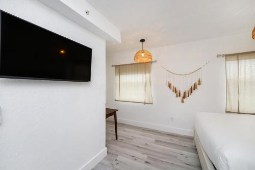 a bedroom with a flat screen tv on the wall at Alton Rd By At Mine Hospitality in Miami Beach