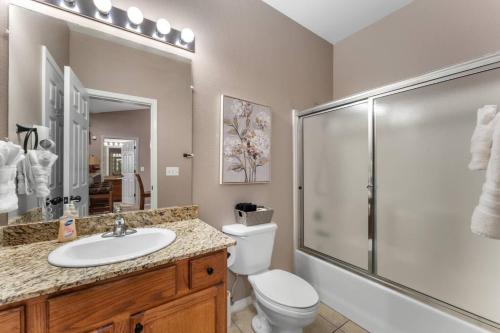 a bathroom with a toilet and a sink and a shower at Golf View Luxe at Stonebridge in Branson West
