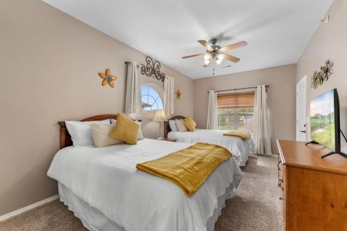 two beds in a bedroom with a ceiling fan at Golf View Luxe at Stonebridge in Branson West