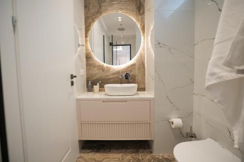 a bathroom with a sink and a mirror at Palmera Vip Villa in Sarandë